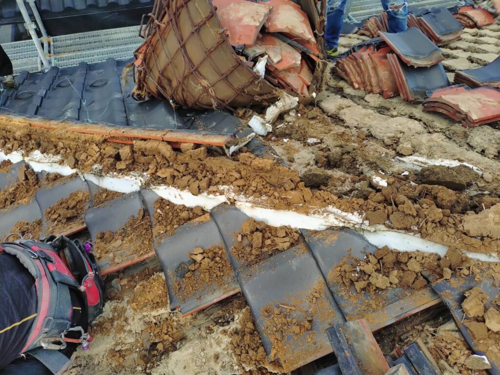 屋根の葺き替え工事で瓦をめくっていきます。棟付近の雨漏りのため、土の色が変わってるのがハッキリ分かります